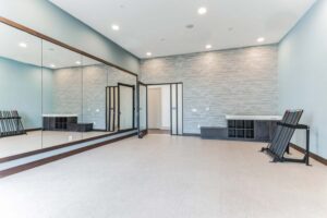 Modern fitness studio with large mirrors, exercise equipment, and sleek design. Ideal for workouts and yoga classes.