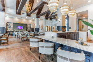 Modern restaurant interior with elegant lighting, wooden beams, and stylish white and wood furniture.