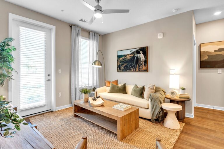 Modern living room with cozy sofa, wood table, and nature-themed artwork, featuring natural light and earthy tones.