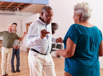 Senior couples dancing joyfully in a bright room, capturing the energy and happiness of the moment.